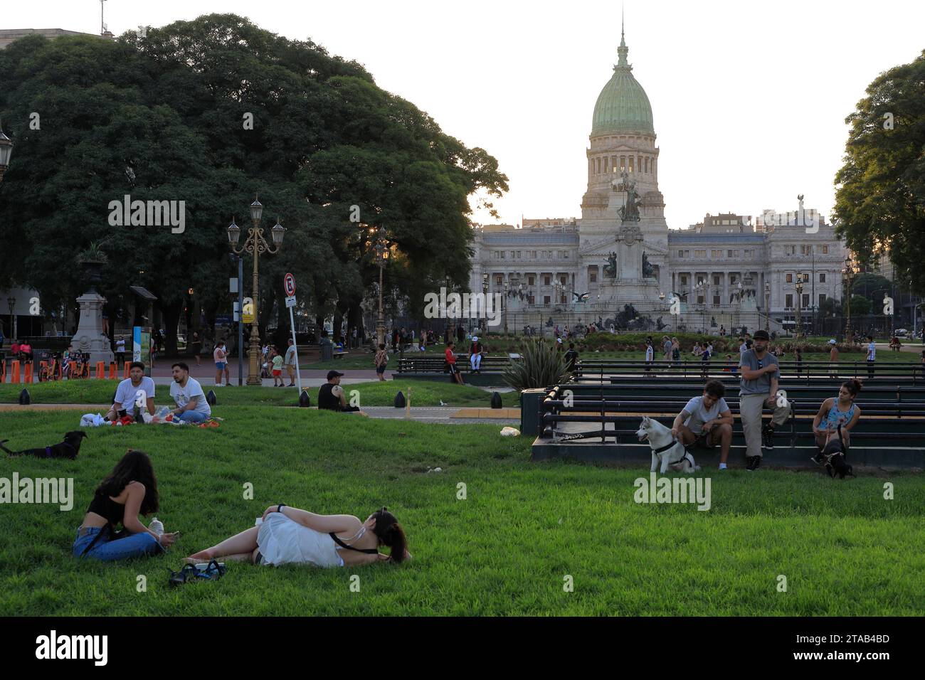 Les gens se détendent dans la Plaza Mariano Moreno pendant le crépuscule avec Plaza del Congreso et le bâtiment du Palais du Congrès national de l'Argentine en arrière-plan.Buenos Aires.Argentina Banque D'Images