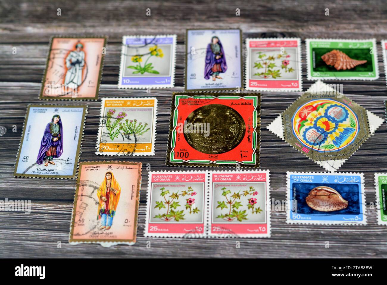 Le Caire, Égypte septembre 21 2022 : le sultanat omanais ancien a utilisé des timbres-poste à différentes époques sur un fond en bois, une couverture avec une série de timbres-poste Banque D'Images