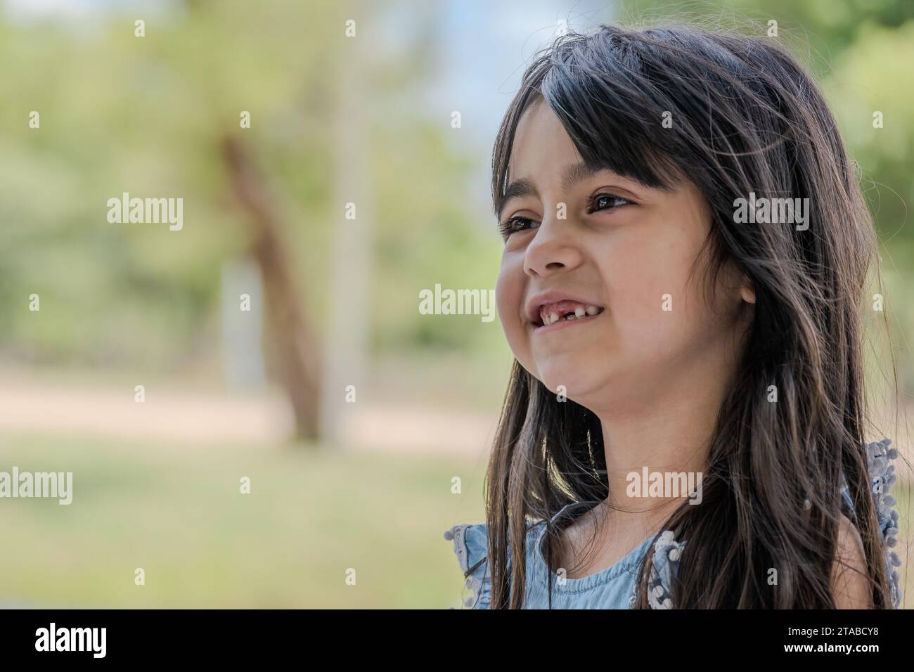 Portrait d'une fille parlant qu'il lui manque une de ses dents de devant. Banque D'Images