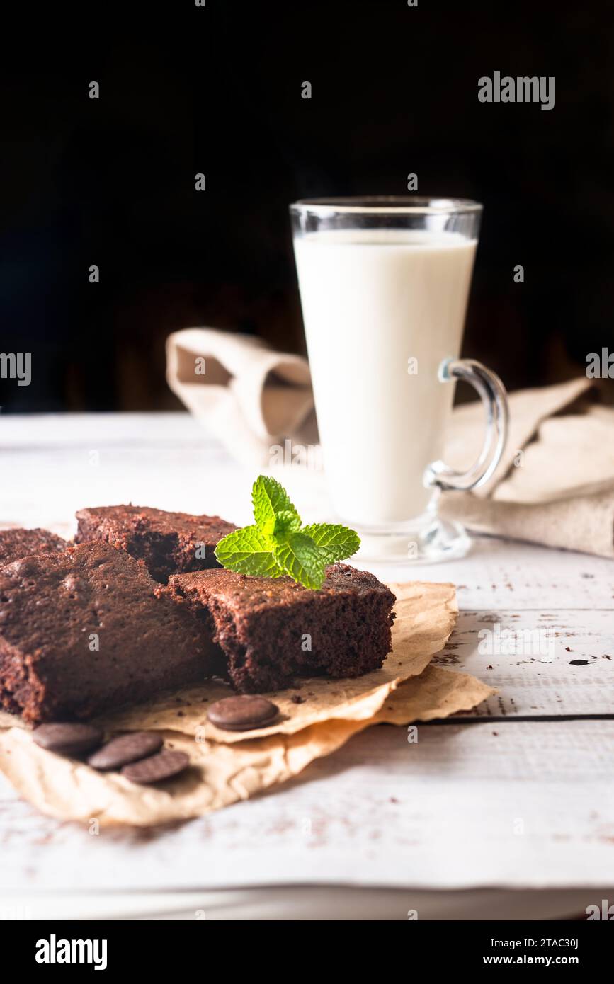 Pile de brownies au chocolat avec verre de lait sur fond de pierre sombre, boulangerie maison et dessert, tarte sucrée Banque D'Images