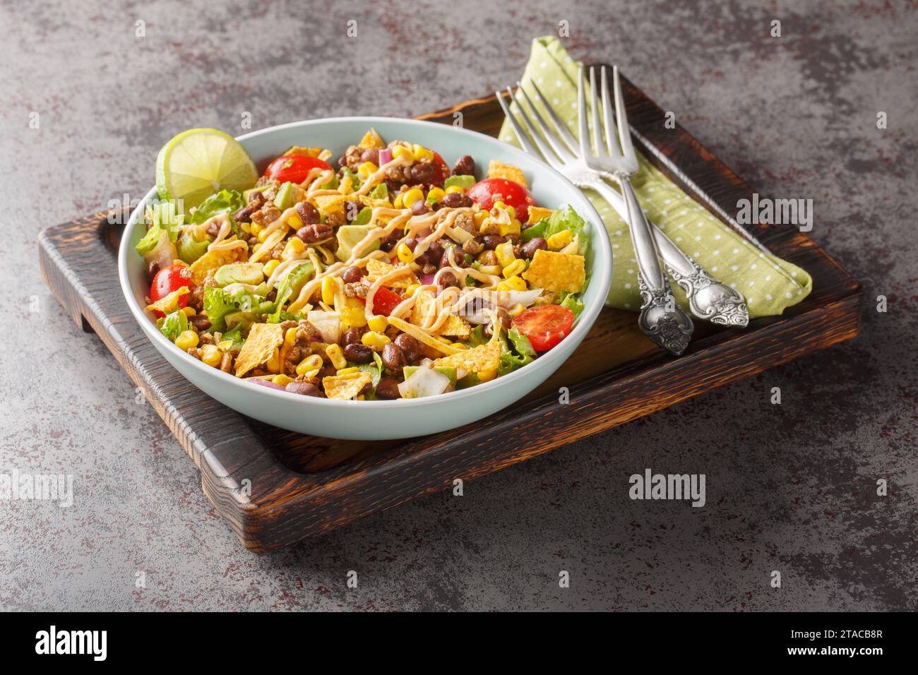 Salade Taco facile est faite avec du bœuf haché assaisonné, de la laitue croustillante, des légumes, du fromage et des garnitures savoureuses en gros plan sur l'assiette sur la table. Horizon Banque D'Images