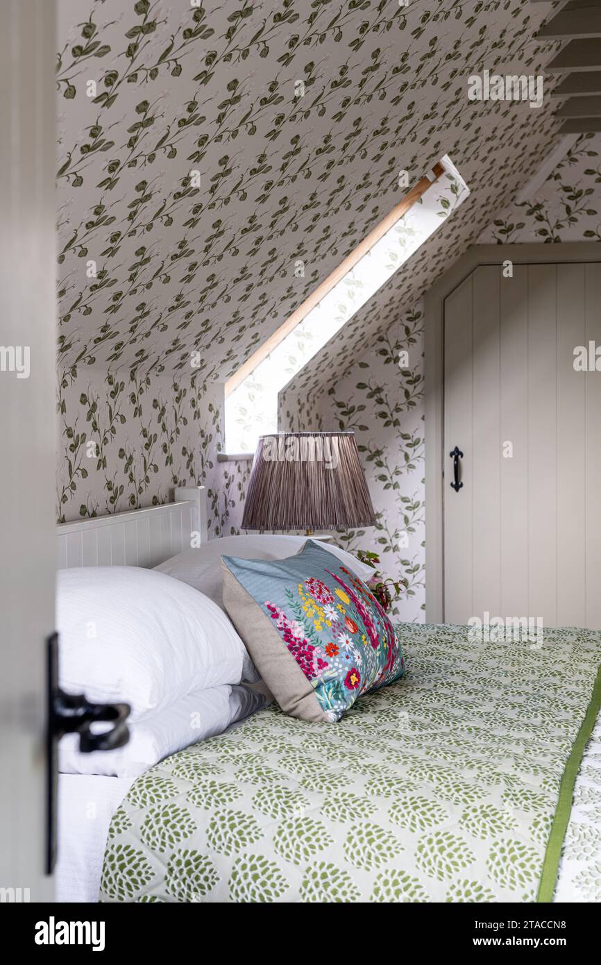 Tissu et papier peint design par Eloise Home dans la chambre mansardée de la maison de style Arts and Crafts des années 1930. Hove, East Sussex, Royaume-Uni. Banque D'Images