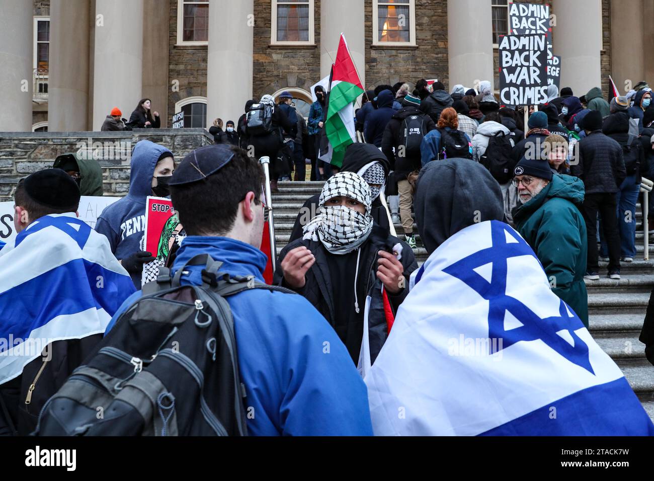 State College, États-Unis. 29 novembre 2023. Un manifestant portant un keffiyeh parle aux partisans d'Israël lors d'un rassemblement pro-palestinien devant Old main sur le campus de l'Université d'État de Pennsylvanie. Les manifestants se rassemblent aux portes d'Allen Street de Penn State, puis marchent vers Old main pour présenter leurs revendications à l'administration de l'université. Les demandes incluent le désinvestissement total des fabricants d'armes et une condamnation de la "guerre de génocide en cours d'Israël contre la Palestine". Crédit : SOPA Images Limited/Alamy Live News Banque D'Images