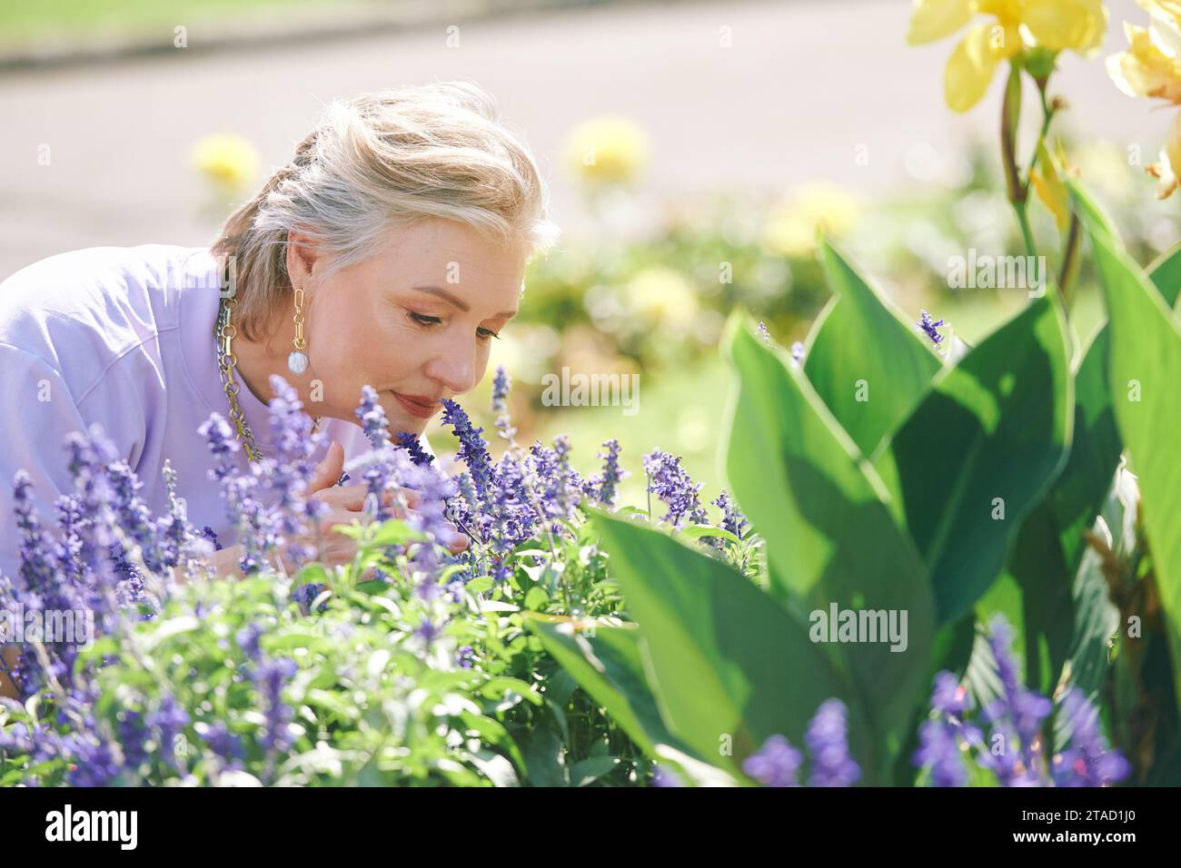 Portrait en plein air de femme âgée heureuse profitant d'une belle journée dans le jardin d'été Banque D'Images