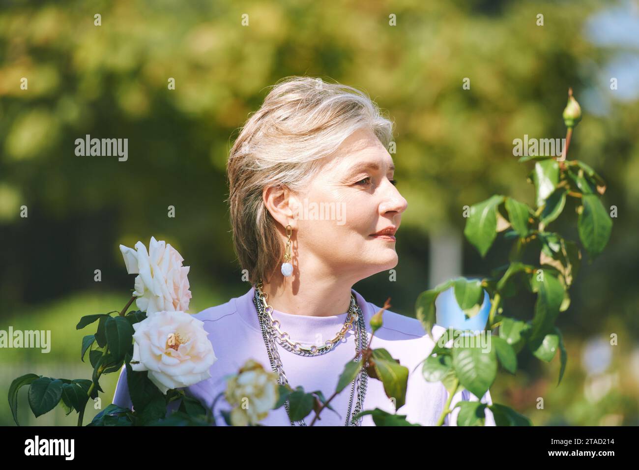 Portrait en plein air de femme âgée heureuse profitant d'une belle journée dans le jardin d'été Banque D'Images