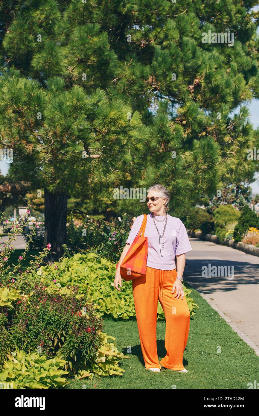 Portrait en plein air de femme âgée heureuse profitant d'une belle journée dans le parc d'été Banque D'Images