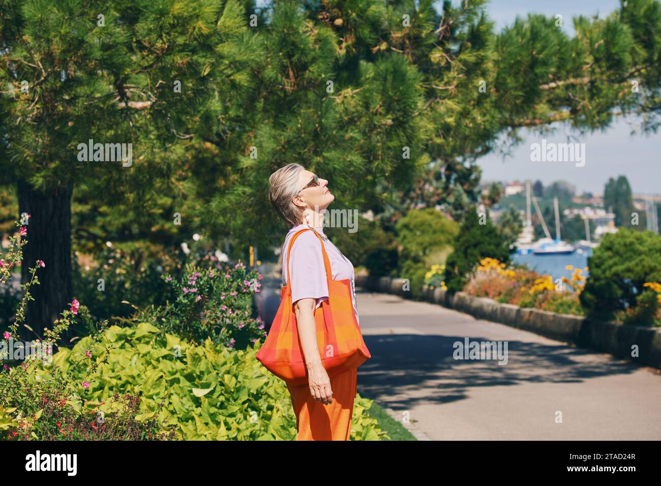 Portrait en plein air de femme âgée heureuse profitant d'une belle journée dans le parc d'été Banque D'Images