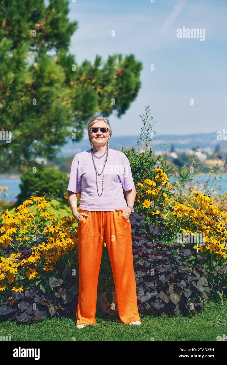Portrait en plein air de femme âgée heureuse profitant d'une belle journée dans le parc d'été Banque D'Images