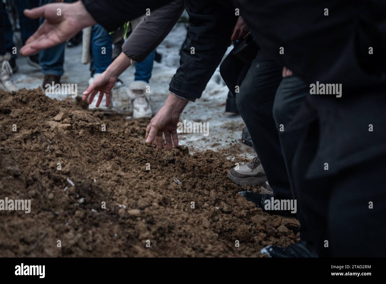 Kiev, Ukraine. 29 novembre 2023. Des parents et des amis jettent de la terre sur la tombe d'un soldat ukrainien décédé Serhiy Pavlichenko, mort au combat dans la région de Zaporizhjia lors de l'invasion continue de l'Ukraine par la Russie, lors de ses funérailles dans un cimetière militaire à Kiev. Depuis que la Russie a commencé son invasion à grande échelle de l'Ukraine le 24 février 2022, des dizaines de milliers de militaires ukrainiens et russes ont été tués. Crédit : SOPA Images Limited/Alamy Live News Banque D'Images