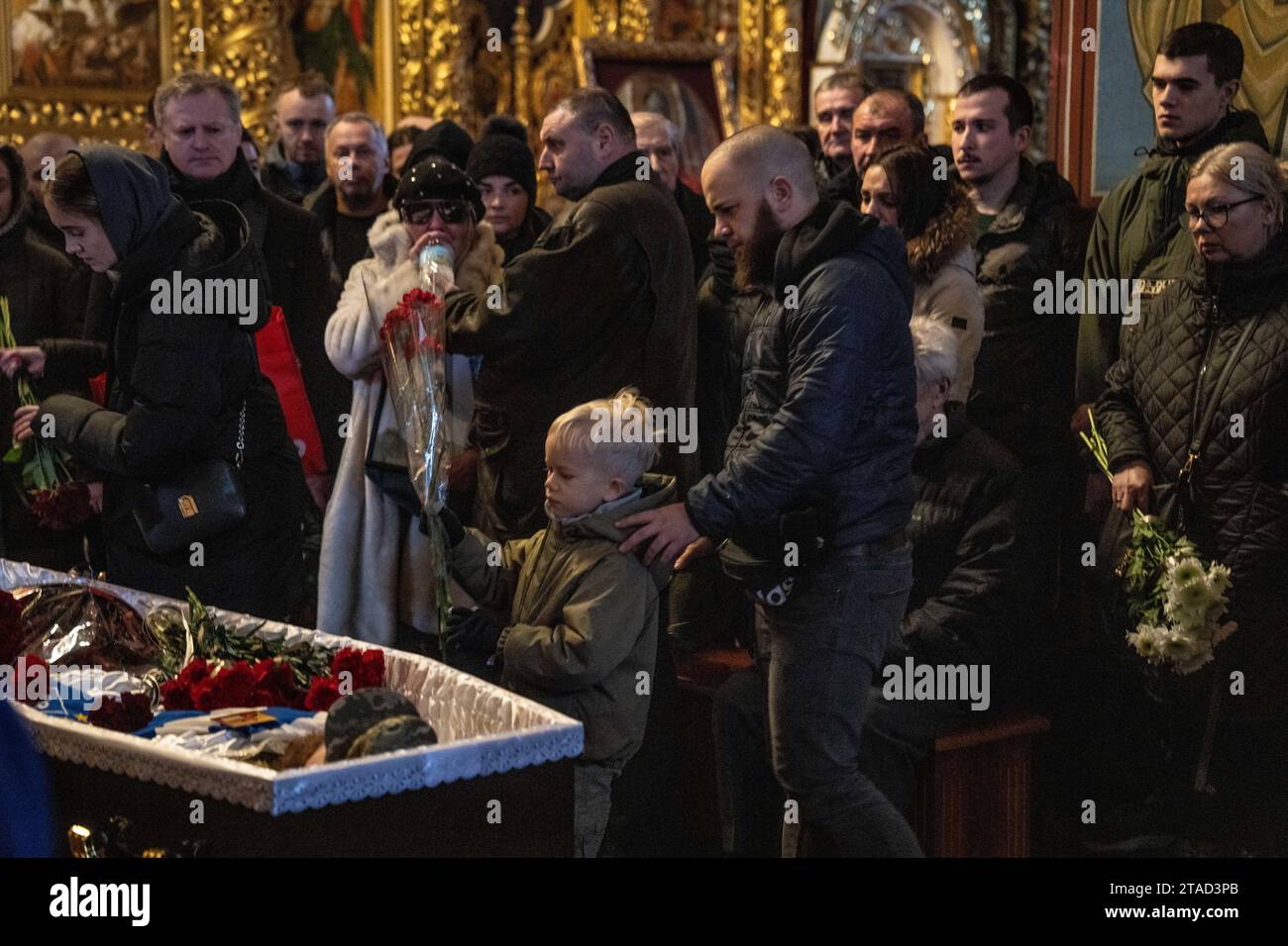 Kiev, Ukraine. 29 novembre 2023. Un enfant dépose des fleurs dans le cercueil du soldat ukrainien Serhiy Pavlichenko, mort au combat dans la région de Zaporizhjhia lors de l'invasion continue de l'Ukraine par la Russie, lors de ses funérailles à St. Cathédrale de Michel à Kiev. Depuis que la Russie a commencé son invasion à grande échelle de l'Ukraine le 24 février 2022, des dizaines de milliers de militaires ukrainiens et russes ont été tués. (Photo Laurel Chor/SOPA Images/Sipa USA) crédit : SIPA USA/Alamy Live News Banque D'Images