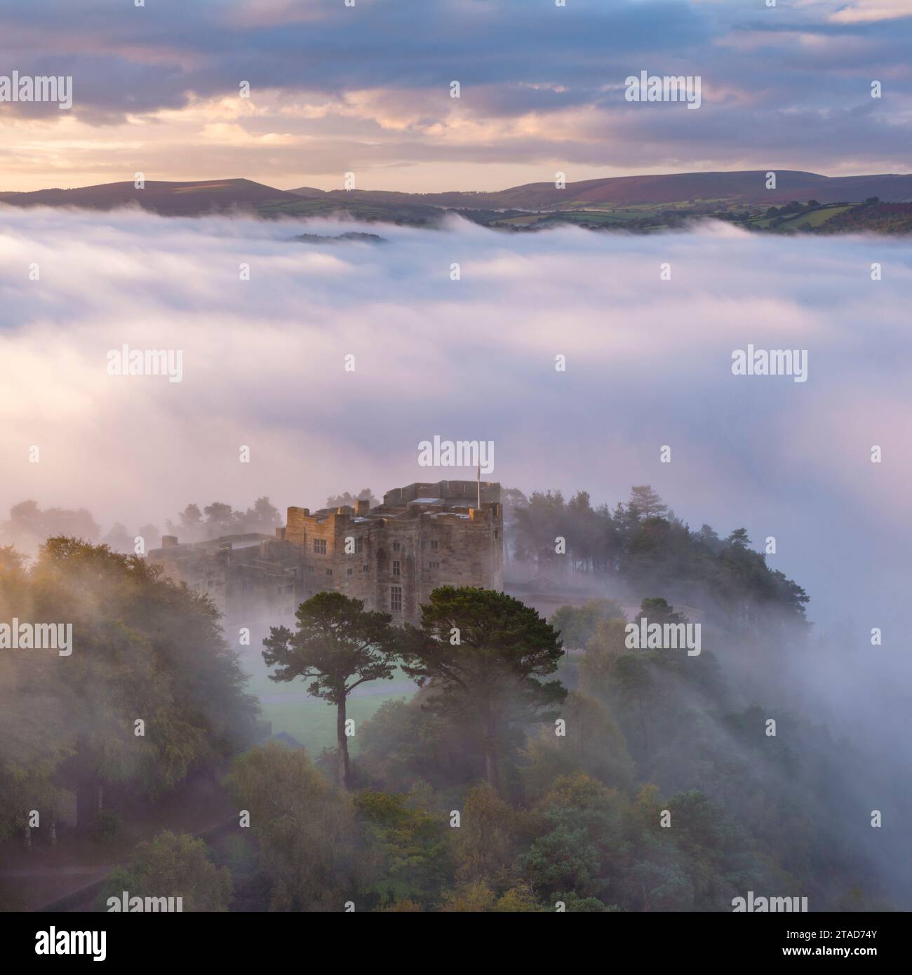 Vue aérienne du château de Drogo émergeant d'une mer de brume matinale, parc national de Dartmoor, Devon, Angleterre. Automne (octobre) 2023. Banque D'Images