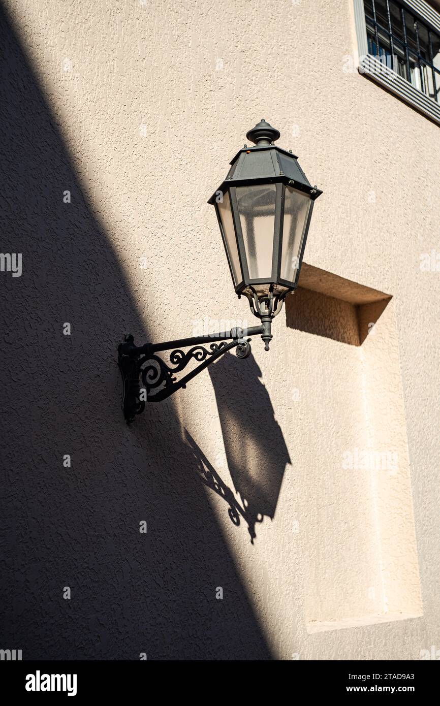 Lampadaire vintage sur le mur avec des ombres profondes Banque D'Images
