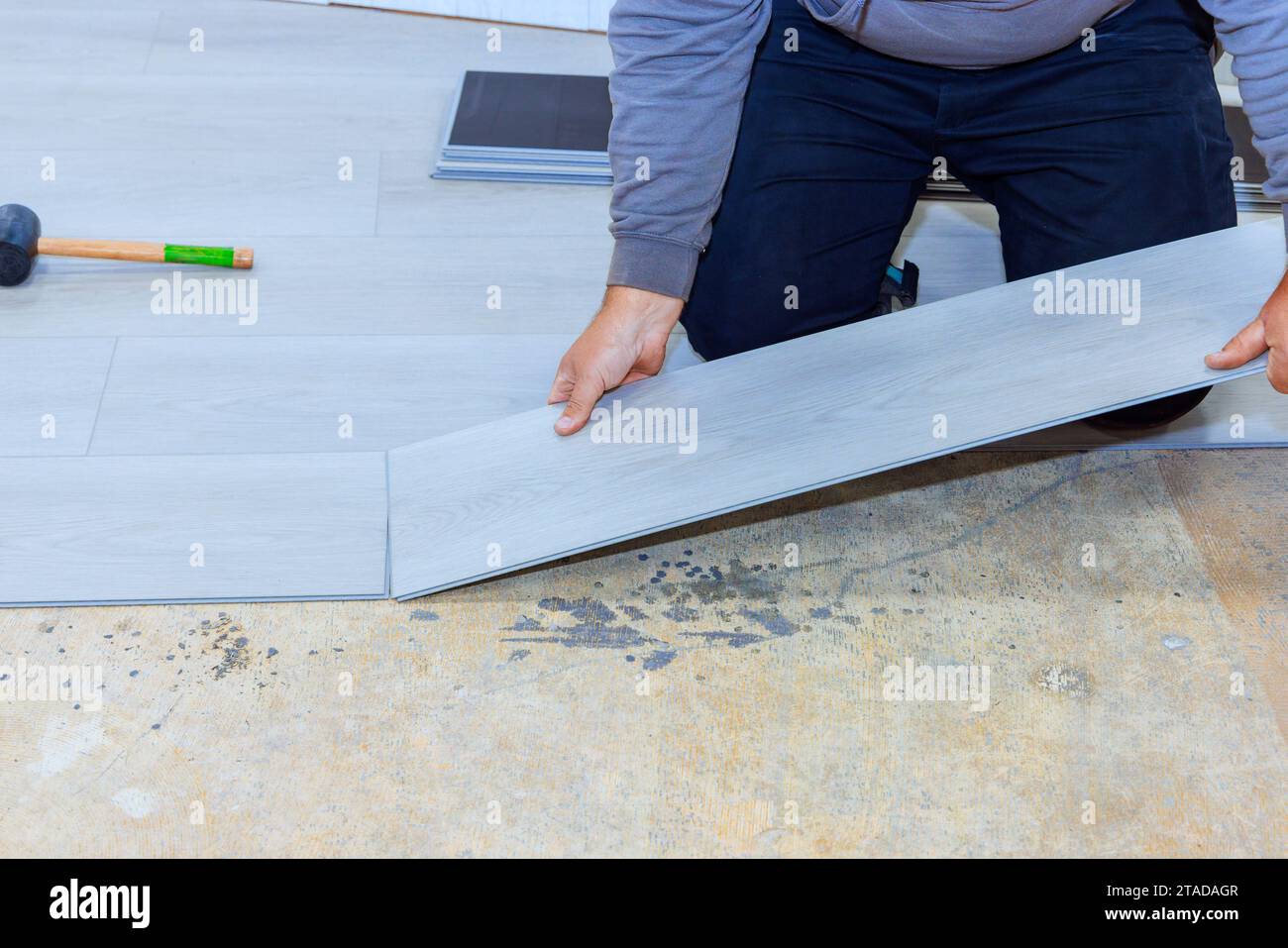 Dans le nouveau travailleur de maison installe un plancher stratifié de vinyle Banque D'Images