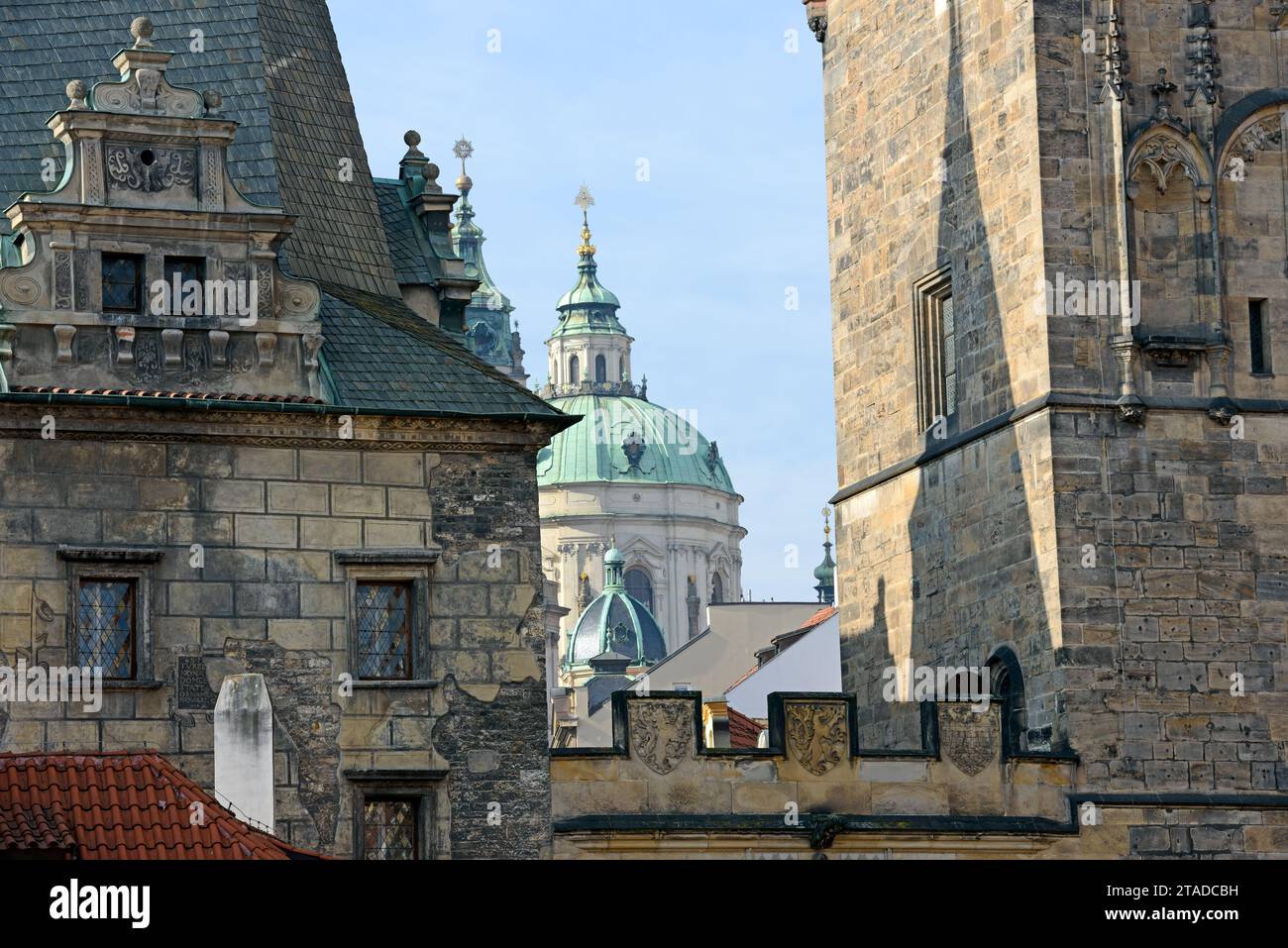 Vue rapprochée du dôme et du clocher de la cathédrale Saint-Nicolas entre les tours du pont Charles sur le côté de la petite ville à Prague, République tchèque. Banque D'Images