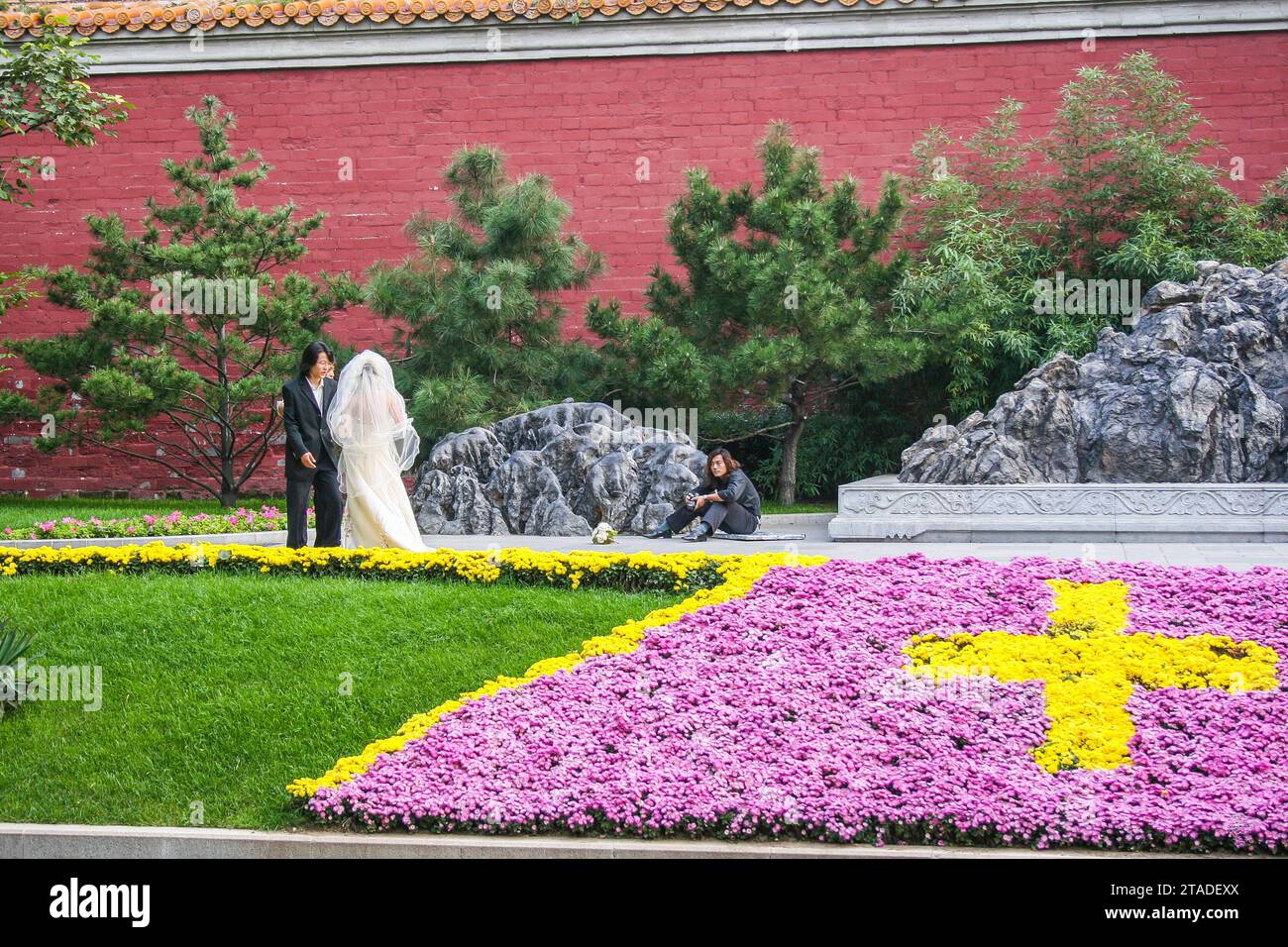 Photographe de mariage prenant une pause dans la photographie d'un couple nouvellement marié dans les Jardins olympiques, Pékin, Chine Banque D'Images