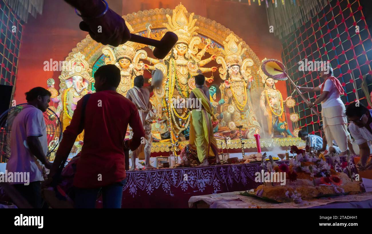 Howrah, Bengale occidental, Inde - 5 octobre 2022 : les Purohits hindous offrent du VOG, de la nourriture sucrée sacrée à la déesse Durga pendant que Dhaakis joue des dhaaks. Banque D'Images