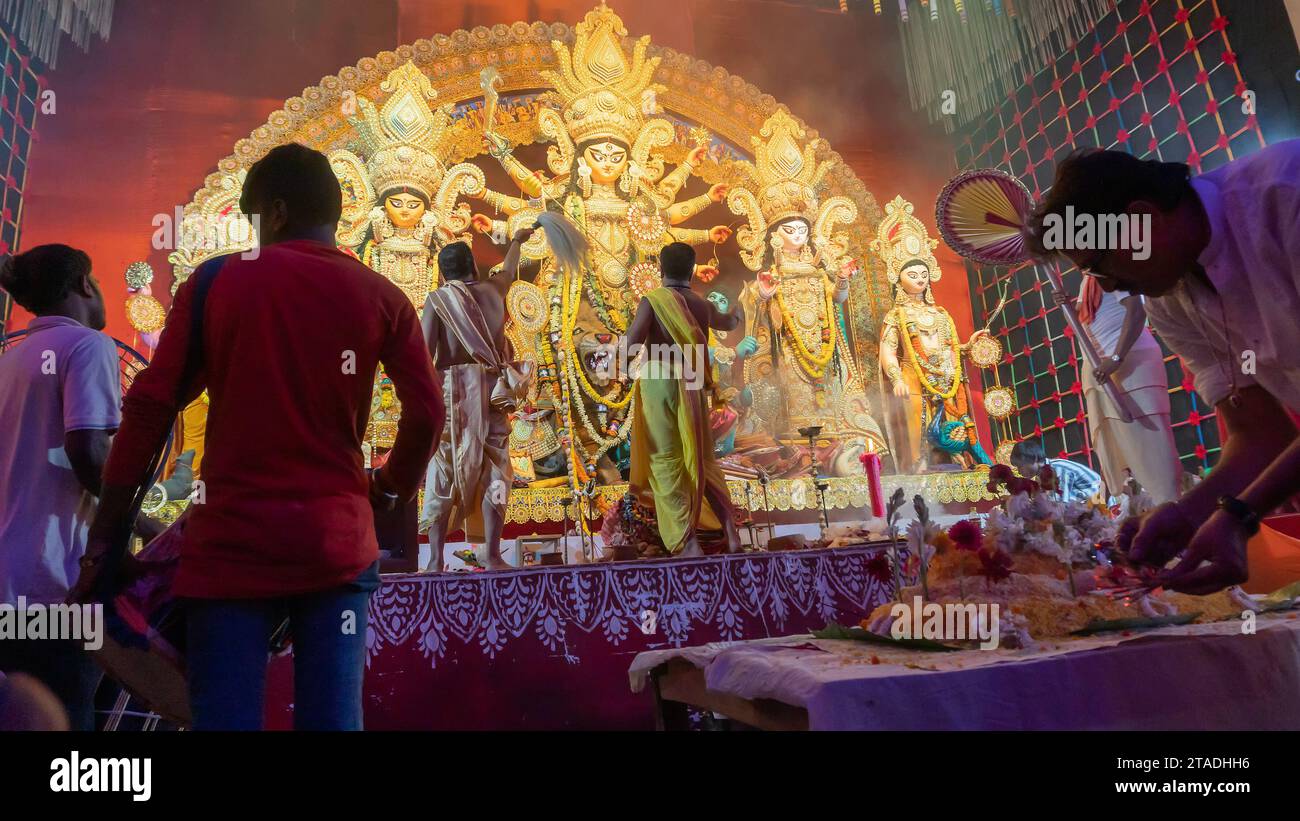 Howrah, Bengale occidental, Inde - 5 octobre 2022 : les Purohits hindous offrent du VOG, de la nourriture sucrée sacrée à la déesse Durga pendant que Dhaakis joue des dhaaks. Banque D'Images