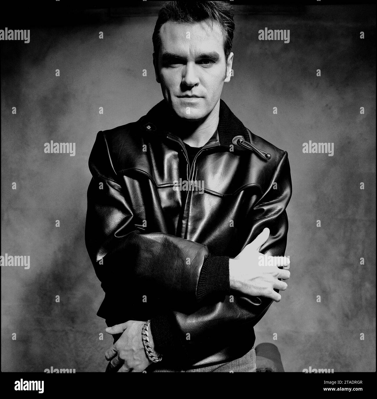 Puissant portrait noir et blanc de mi-plan de la légendaire rockstar, chanteur/compositeur Morrissey en veste en cuir et en jeans bleus pour promouvoir son single « Sunny » en 1995 pour Parlophone Records. Banque D'Images