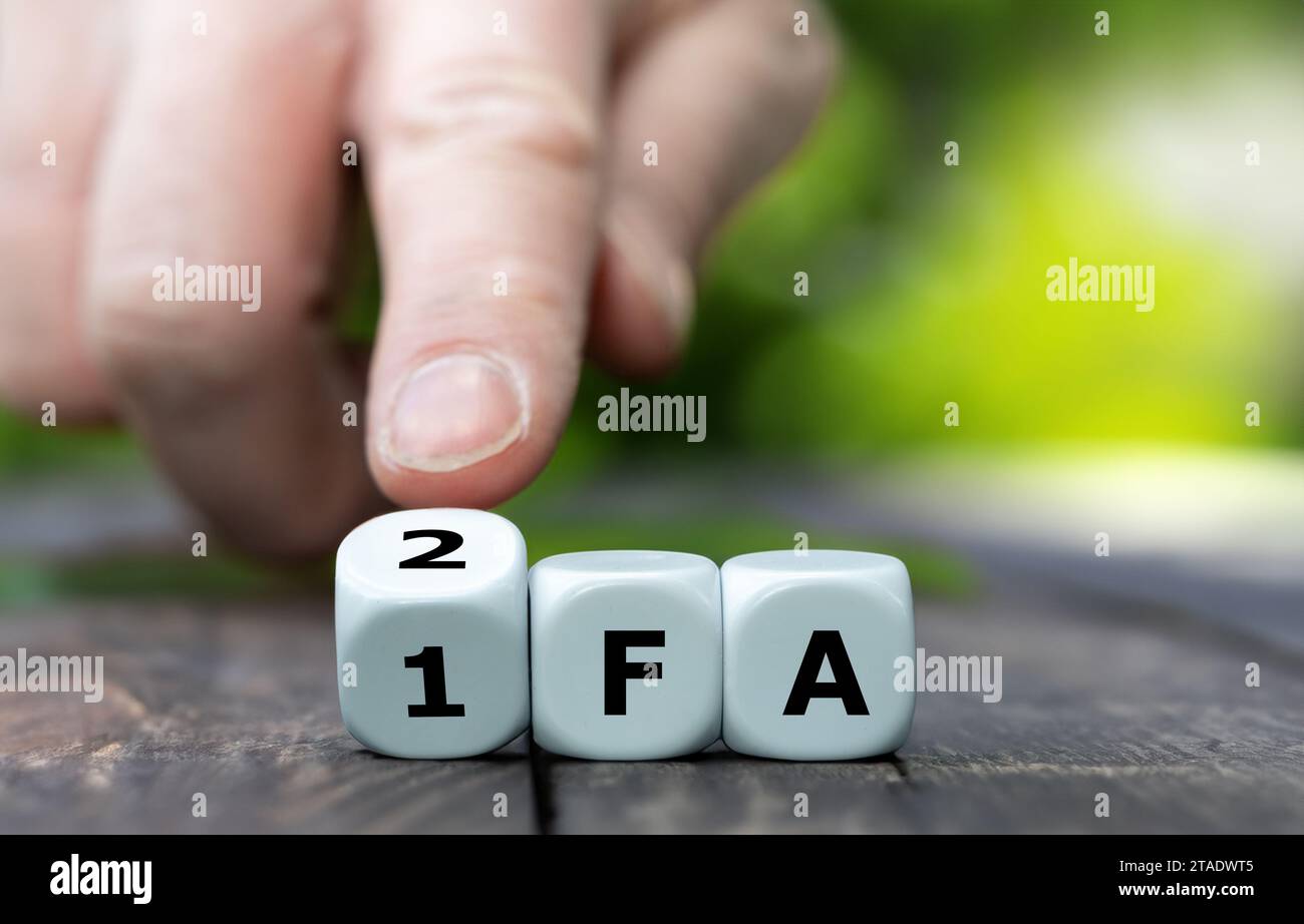 Hand tourne des dés et change l'abréviation 1FA (authentification à un facteur) en 2FA (authentification à deux facteurs). Banque D'Images