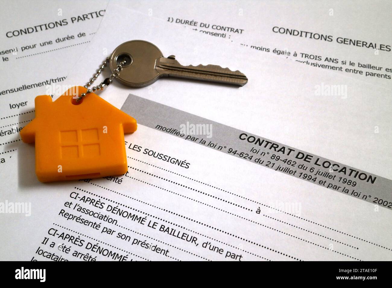 Une clé d'appartement attachée à son porte-clés sur le dessus d'un contrat de location de propriété française. Banque D'Images