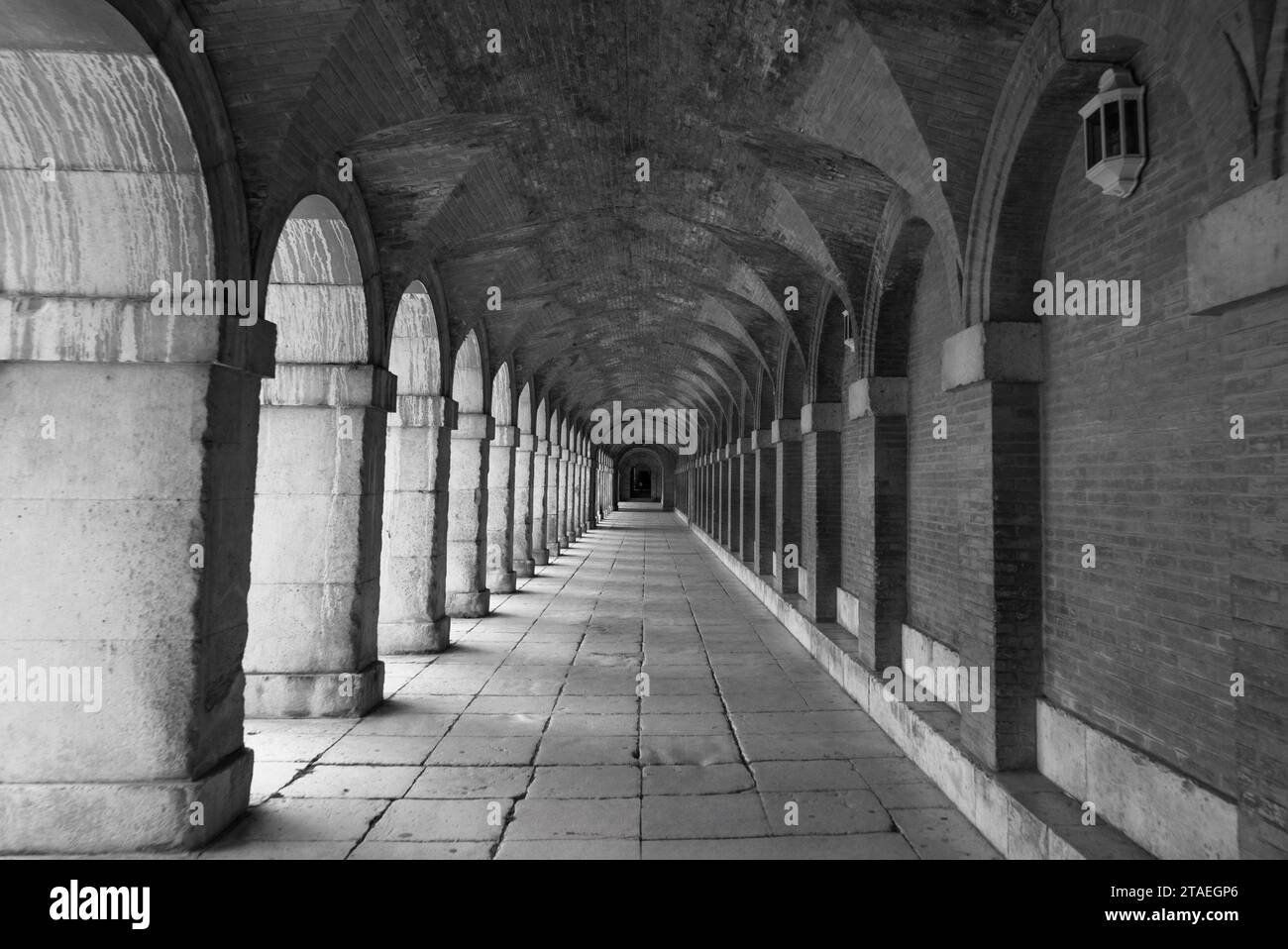 Couloir symétrique avec arches et colonnes du palais royal d'Aranjuez en noir et blanc. Madrid. Espagne Banque D'Images