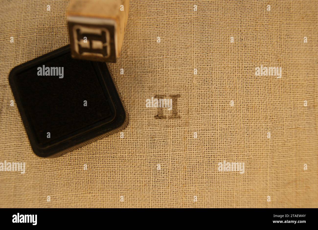 Timbre lettre H sur toile de lin. Lettres sur tissu. Banque D'Images