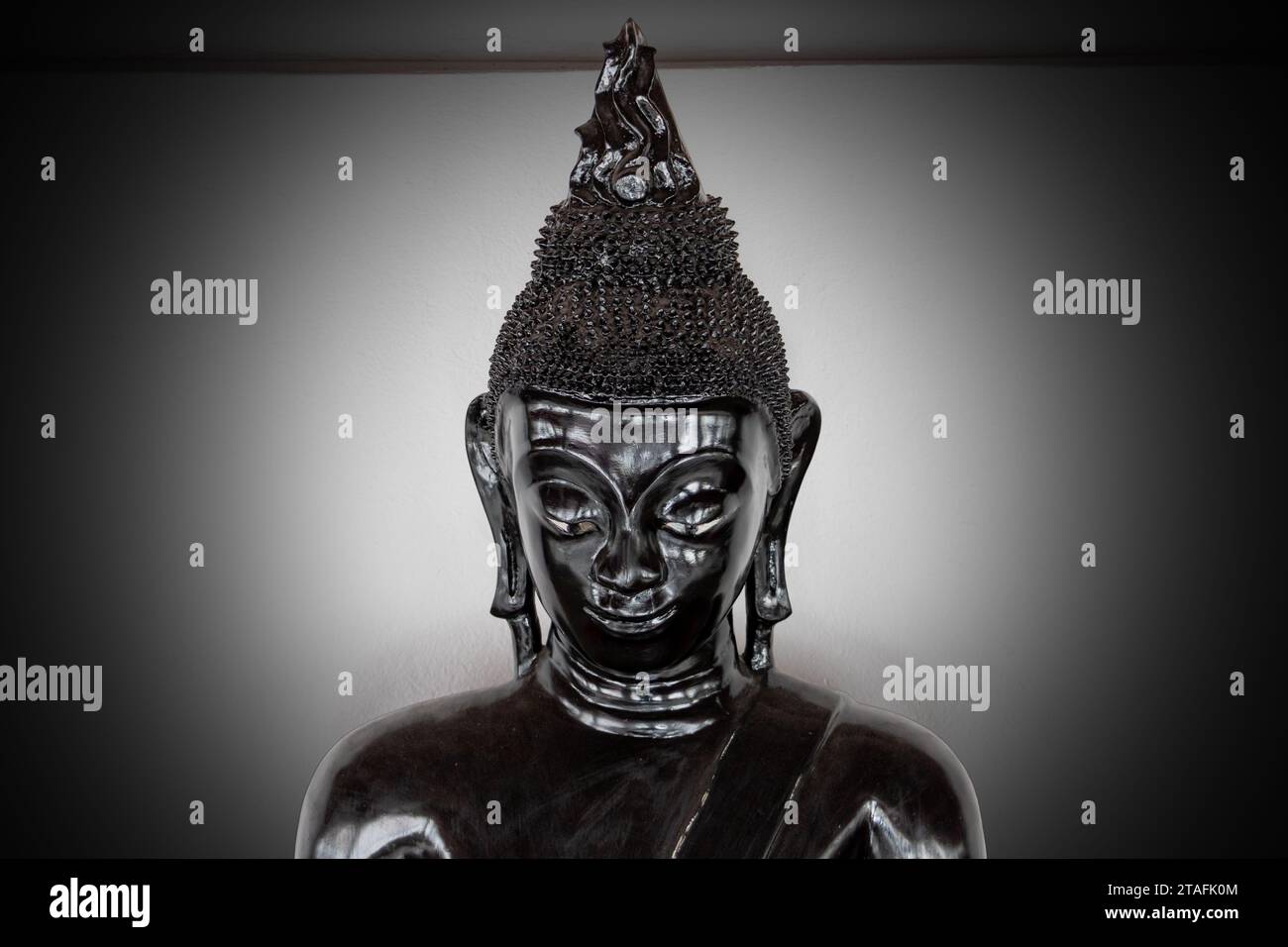 Statue de Bouddha noir sur un fond clair Banque D'Images