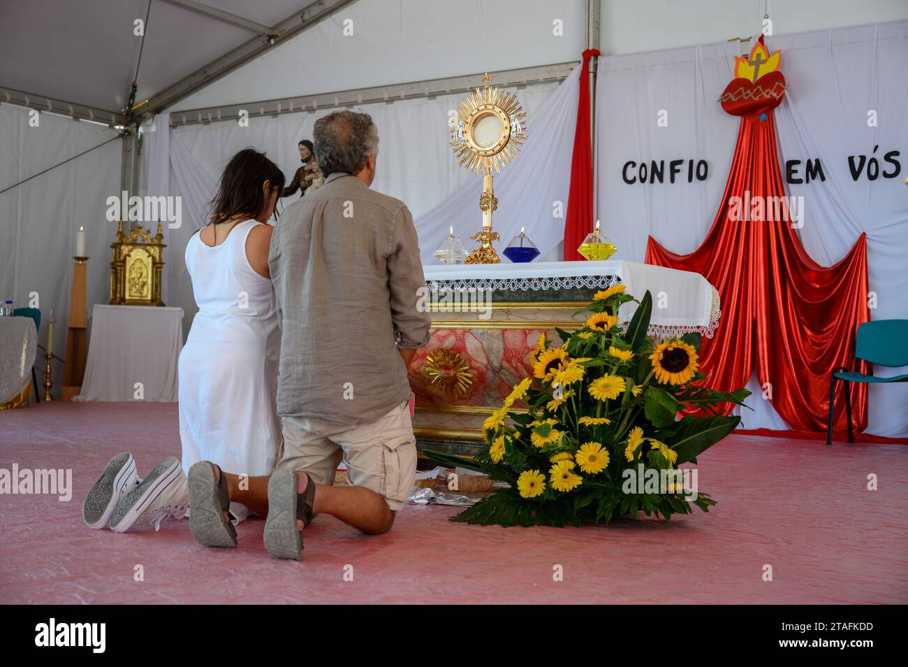 Un couple d'âge moyen agenouillé dans l'adoration du Saint Sacrement. Une tente au Sanctuaire du Christ Roi à Lisbonne, Portugal pendant les JMJ 2023. Banque D'Images