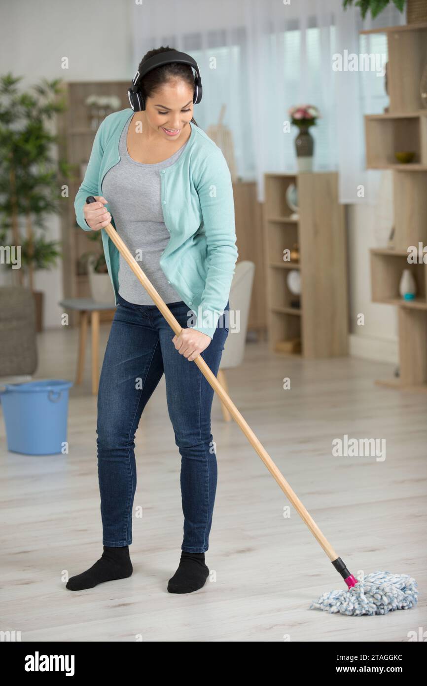 femme heureuse ou femme au foyer avec le sol de nettoyage de vadrouille Banque D'Images