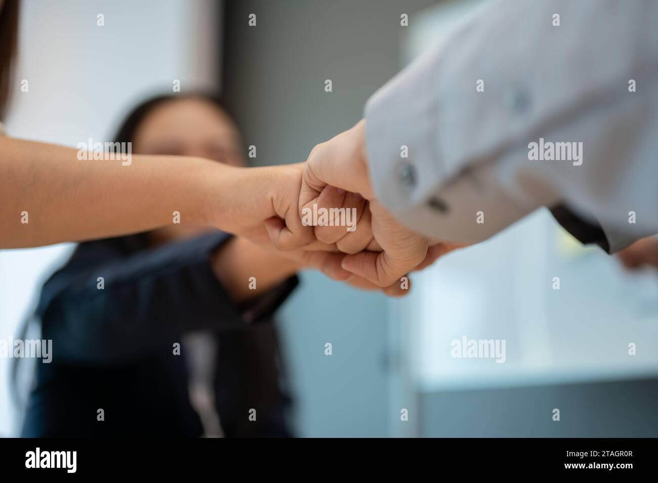 Image rapprochée de divers hommes d'affaires qui donnent un coup de poing à la réunion. team building, travail d'équipe, unité, collègues unissent leurs mains, motivant Banque D'Images