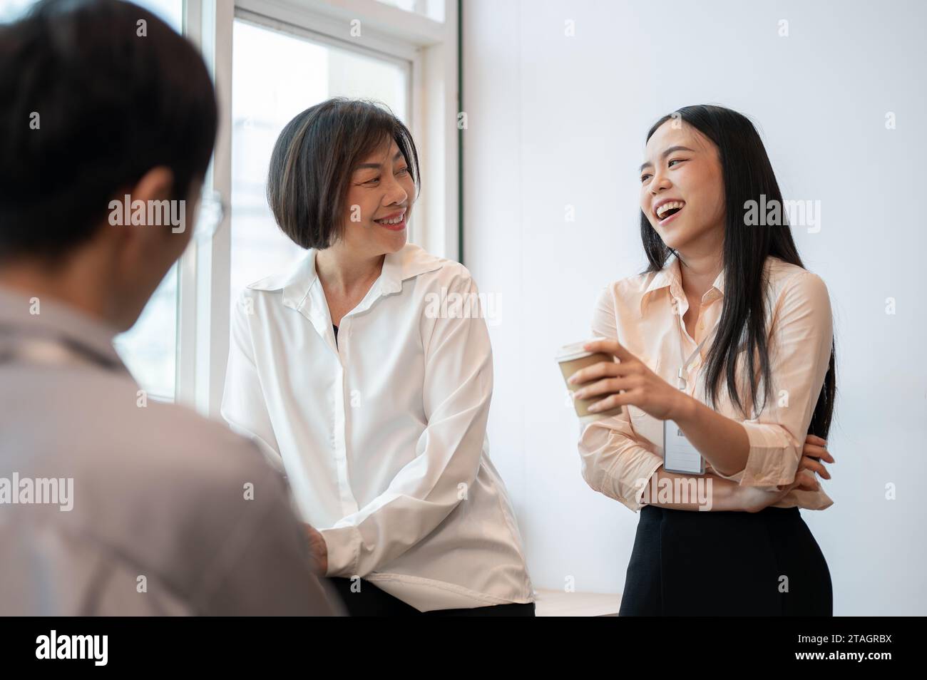 Groupe de collègues asiatiques heureux et divers hommes d'affaires aiment parler, rire et partager leurs idées pendant une pause café au bureau. Banque D'Images