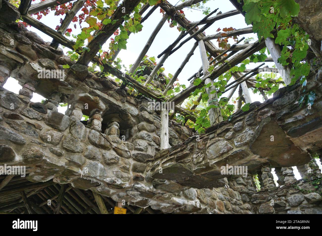 Vue inclinée à travers les poutres apparentes d'un pavillon en pierre au parc d'État de Gillette Castle, Connecticut. La structure de maçonnerie est tombée en ruine Banque D'Images