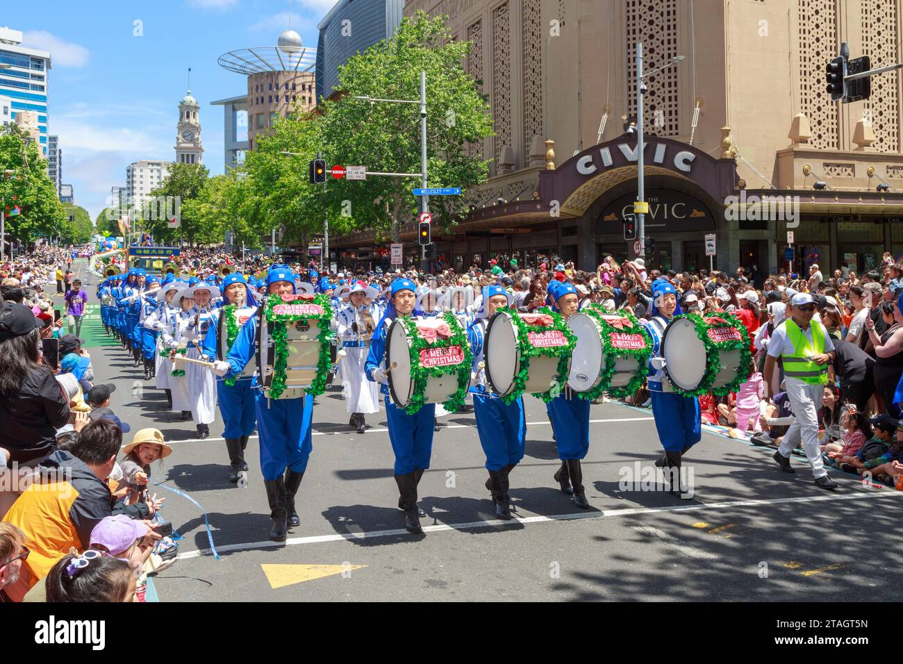 Un groupe de batteurs, leurs tambours décorés de guirlandes et de signes « Joyeux Noël », participent à la Parade de Noël des agriculteurs à Auckland, en Nouvelle-Zélande Banque D'Images