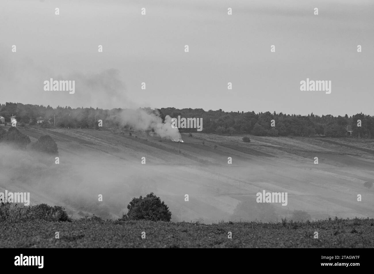 Brûler l'herbe est nocif pour l'environnement. Horizon nuageux des montagnes de l'herbe brûlante et de la fumée, catastrophe environnementale, pollution de l'air. Banque D'Images