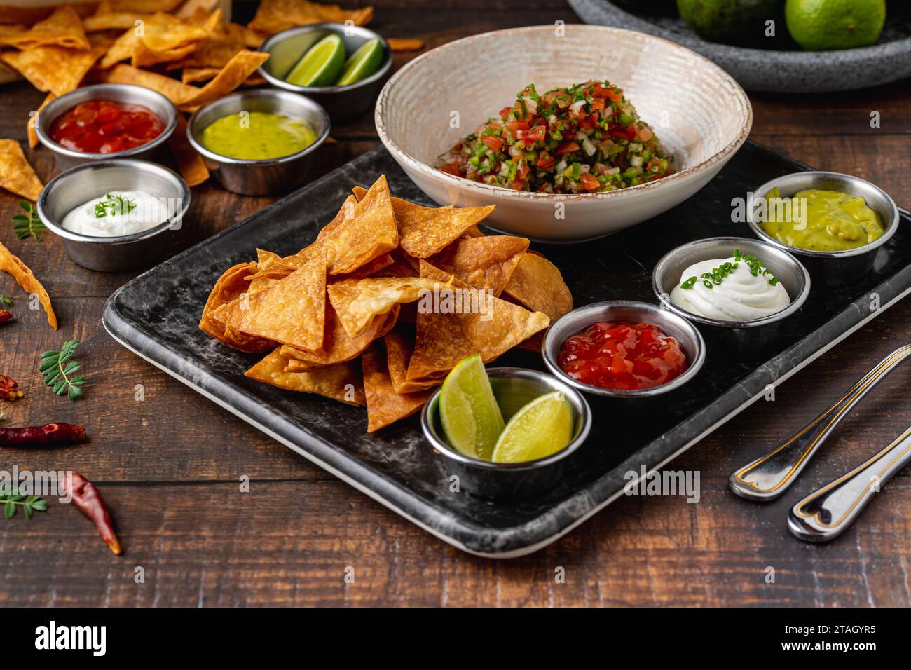 Pico de gallo de la cuisine mexicaine avec sauces trempées sur la table en bois Banque D'Images