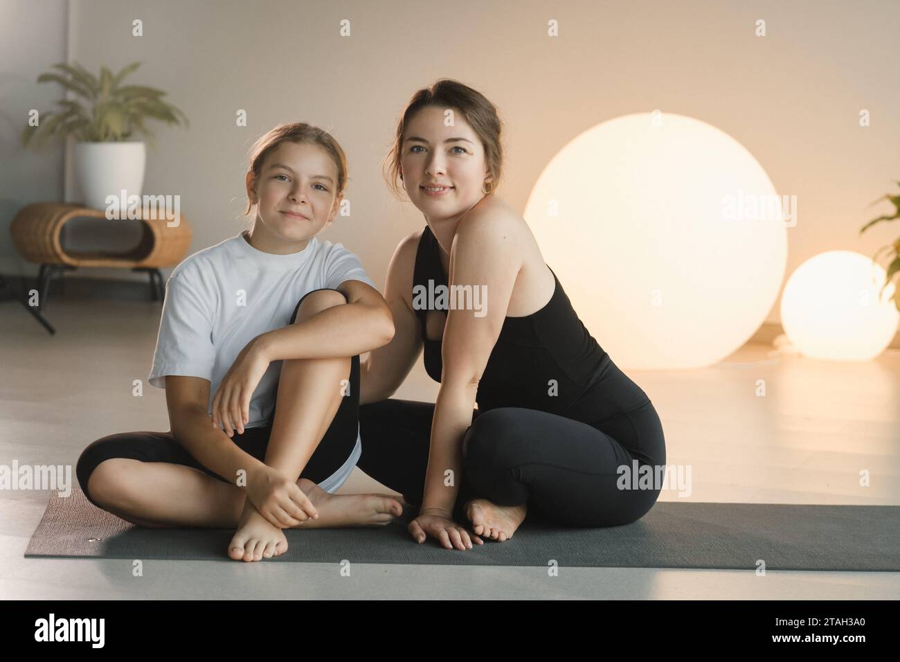 portrait d'une mère et la fille d'un adolescent en vêtements de sport serrant, qui sont ensemble dans une salle de fitness. le concept de sport familial. Banque D'Images