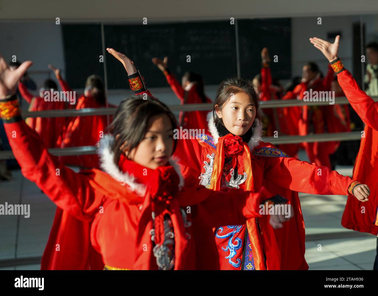 Chongqing, la Chine Chongqing. 28 novembre 2023. Les élèves pratiquent la « bian lian » traditionnelle, ou compétences qui changent le visage, dans une salle de classe de danse à l'école primaire Wu'an dans le comté de Dianjiang, dans le sud-ouest de la Chine, Chongqing, le 28 novembre 2023. Avec plus de 600 élèves, l'école primaire Wu'an a coopéré ces dernières années avec l'artiste folklorique Li Yong et a ajouté le changement de visage comme une partie spéciale de son programme. La technique de changement de visage est l'une des parties les plus célèbres de l'opéra du Sichuan, où les acteurs modifient rapidement leur maquillage de visage avec un effet époustouflant et dramatique. Crédit : Liu Chan/Xinhua/Alamy Live News Banque D'Images