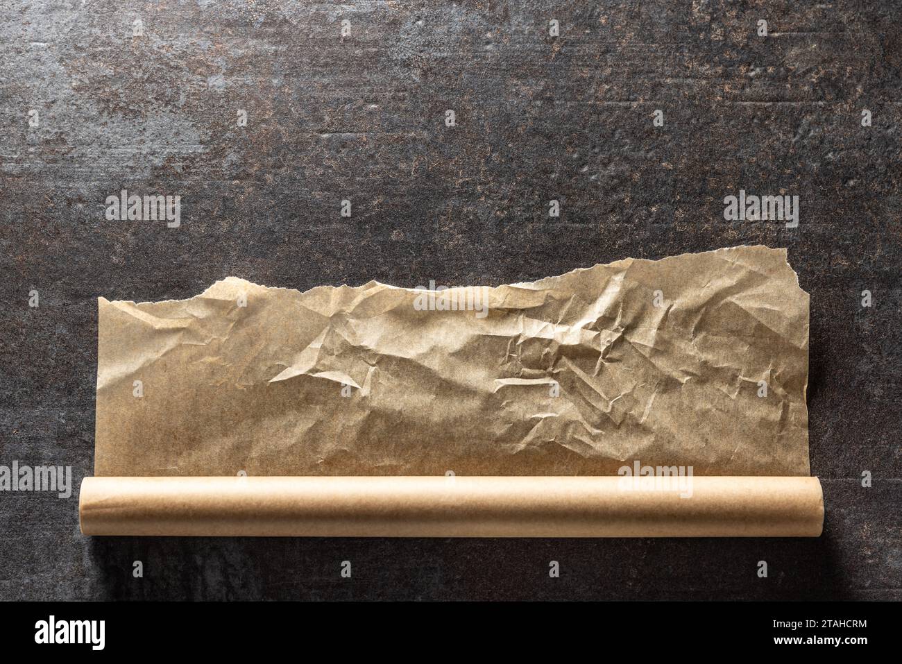 Rouleau du papier sulfurisé sur fond de béton foncé. Banque D'Images