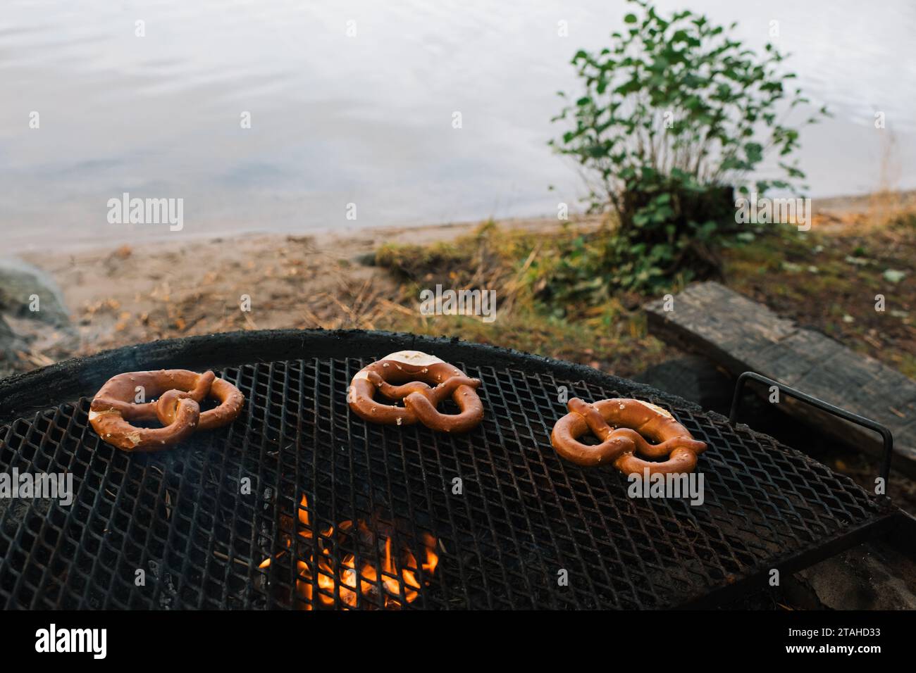 bretzels cuisinant sur un feu ouvert au bord de la mer Banque D'Images