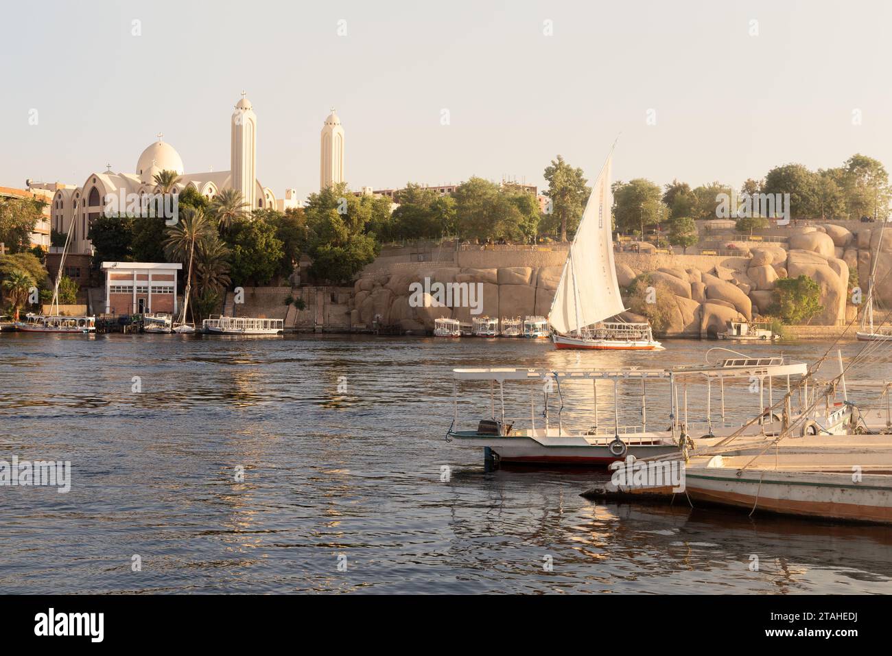 Felucca traditionnelle naviguant sur le Nil pendant l'heure dorée à Assouan Banque D'Images