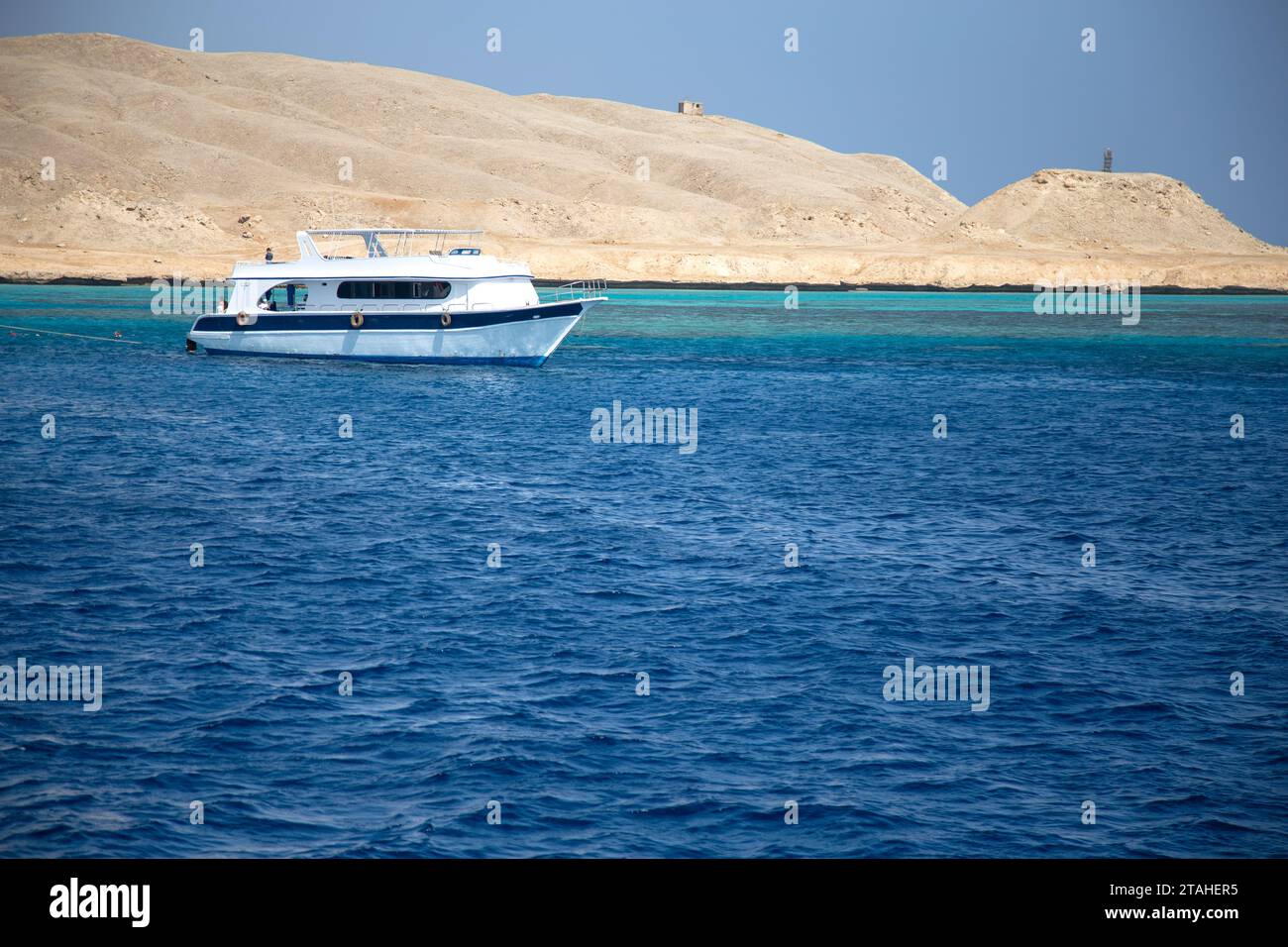 Petit bateau de plongée naviguant dans l'eau bleue de la mer Rouge, Hurghada, Egypte Banque D'Images