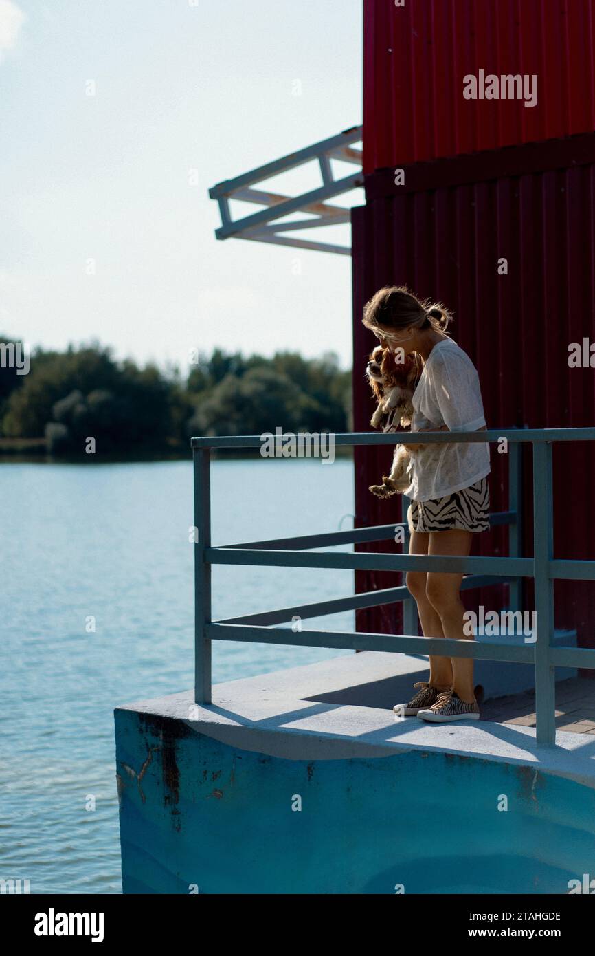 Jeune femme marchant avec un chien, cavalier Charles. Banque D'Images