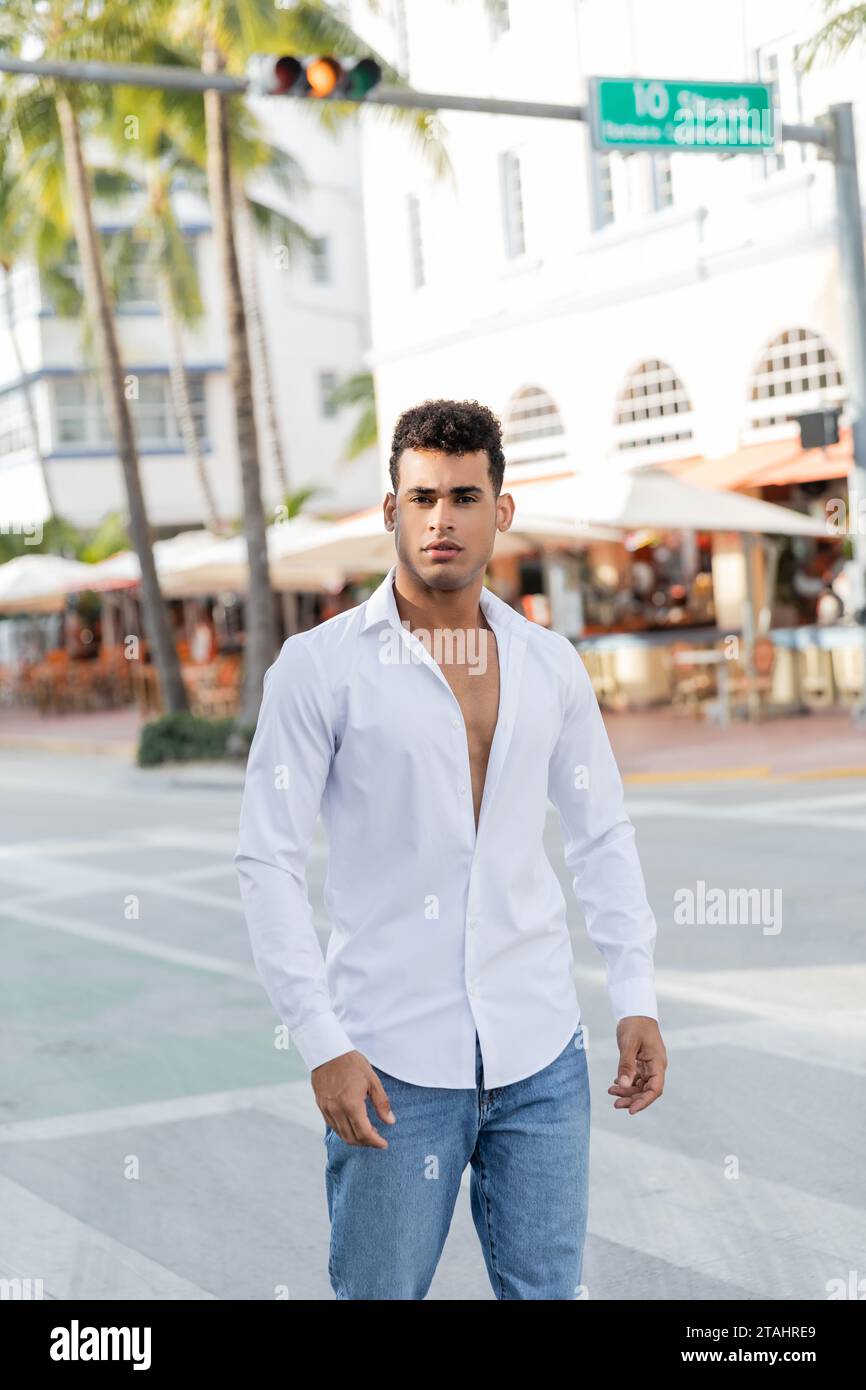 Portrait de jeune homme cubain en jeans et chemise blanche regardant la caméra à Miami, South Beach Banque D'Images