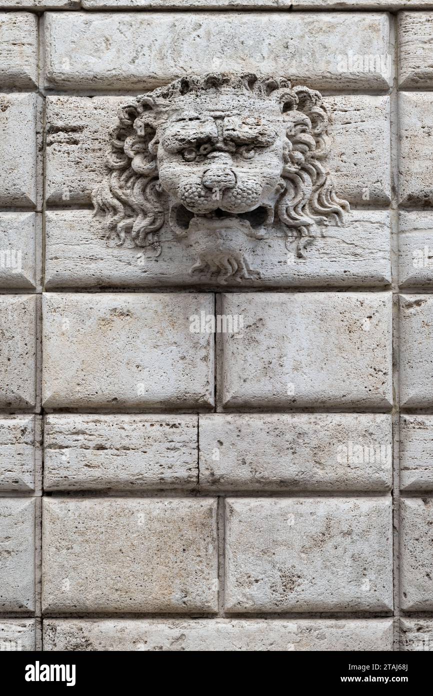 Une tête de lion décorative est montée sur un mur de pierre dans le village italien de Montepulciano, Toscane, Italie. Banque D'Images