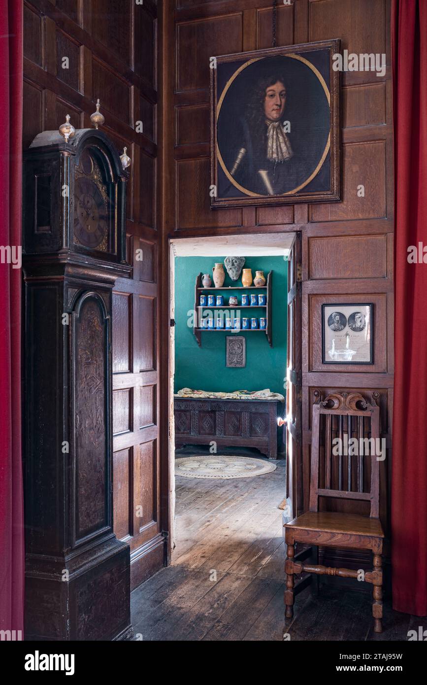 Horloge de grand-père et portrait encadré doré avec lambris élisabéthains à Wolfeton House, Dorset, Angleterre, Royaume-Uni. Banque D'Images