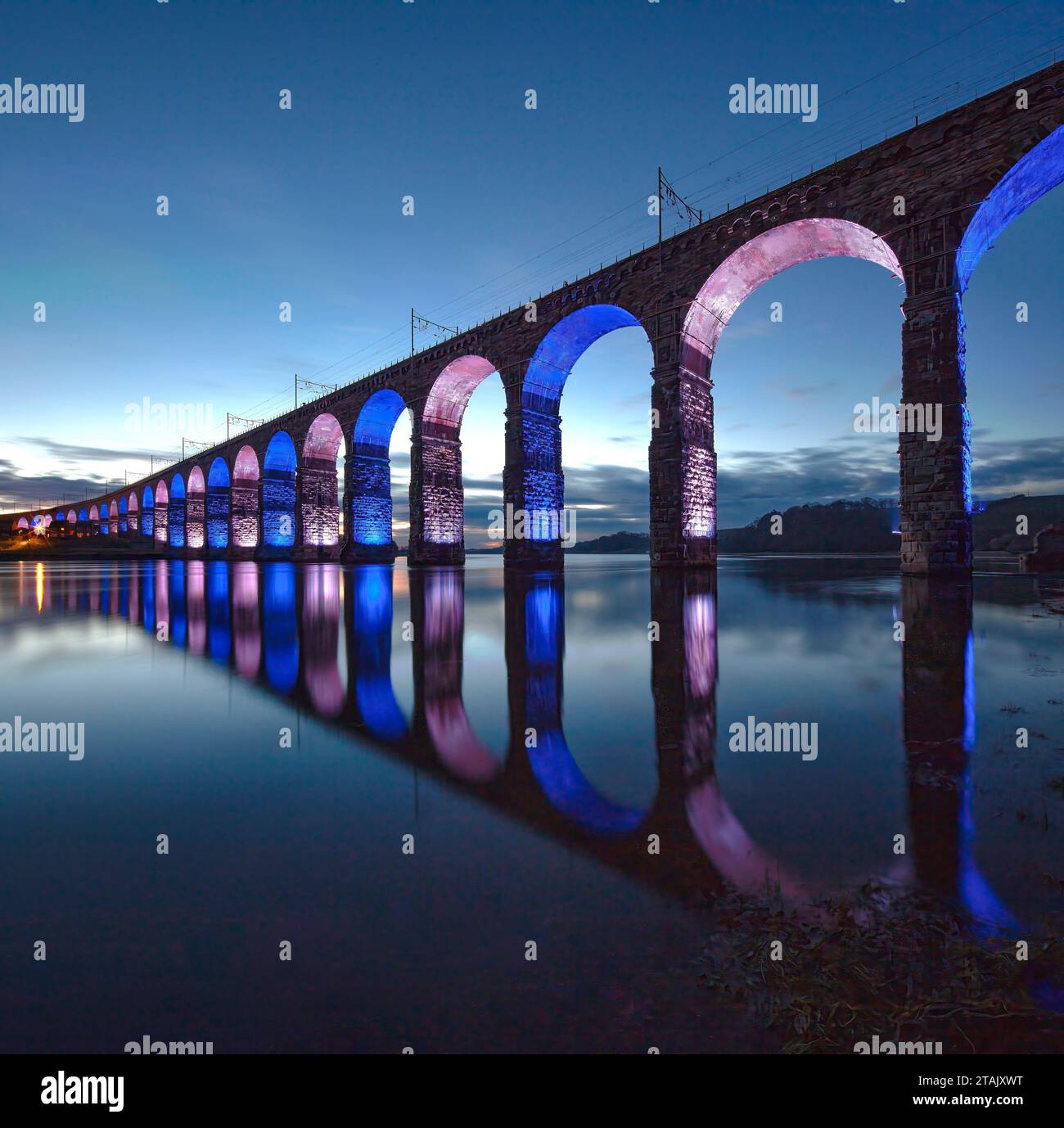 Vue au crépuscule du Royal Border Bridge éclairé à Berwick upon Tweed reflété dans la rivière Tweed par une nuit d'hiver claire dans le Northumberland Banque D'Images