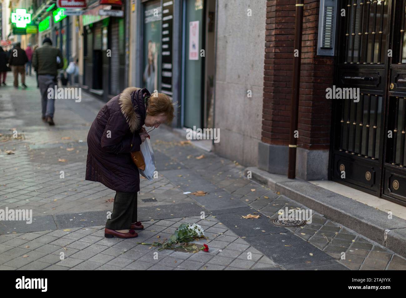 Madrid, Madrid, Espagne. 1 décembre 2023. Une femme observe la Stolpersteine pour commémorer Eugenio Charlan Rey, qui a été libéré du camp de concentration de Mauthausen-Gusen, lors d'un acte pour placer huit Stolpersteine, de républicains espagnols, déportés dans les camps nazis, qui vivaient dans le quartier madrilène d'Arganzuela à Madrid. (Image de crédit : © Luis Soto/ZUMA Press Wire) USAGE ÉDITORIAL SEULEMENT! Non destiné à UN USAGE commercial ! Banque D'Images