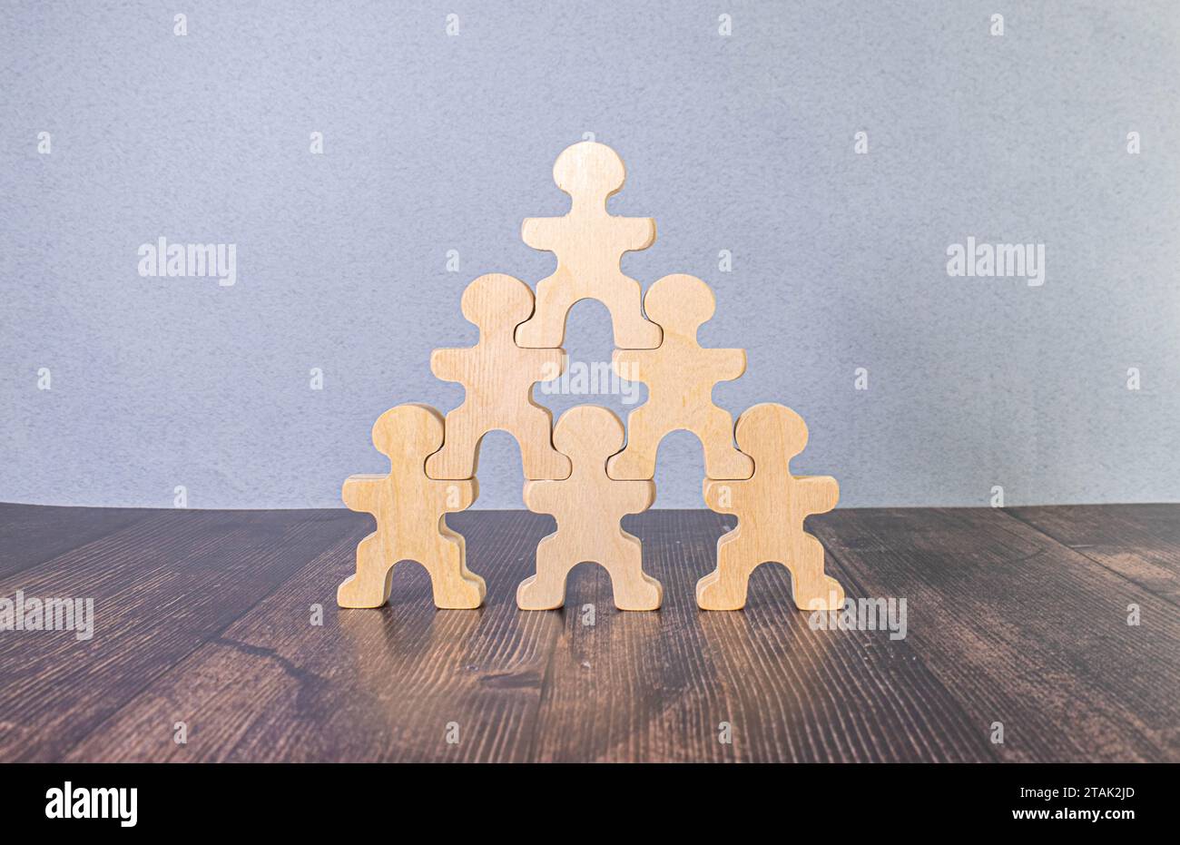 poupées nichantes en bois non peintes se tiennent les unes sur les autres sur fond blanc. symbole traditionnel des poupées matryoshka. acrobatie, équilibre, travail d'équipe con minimal Banque D'Images