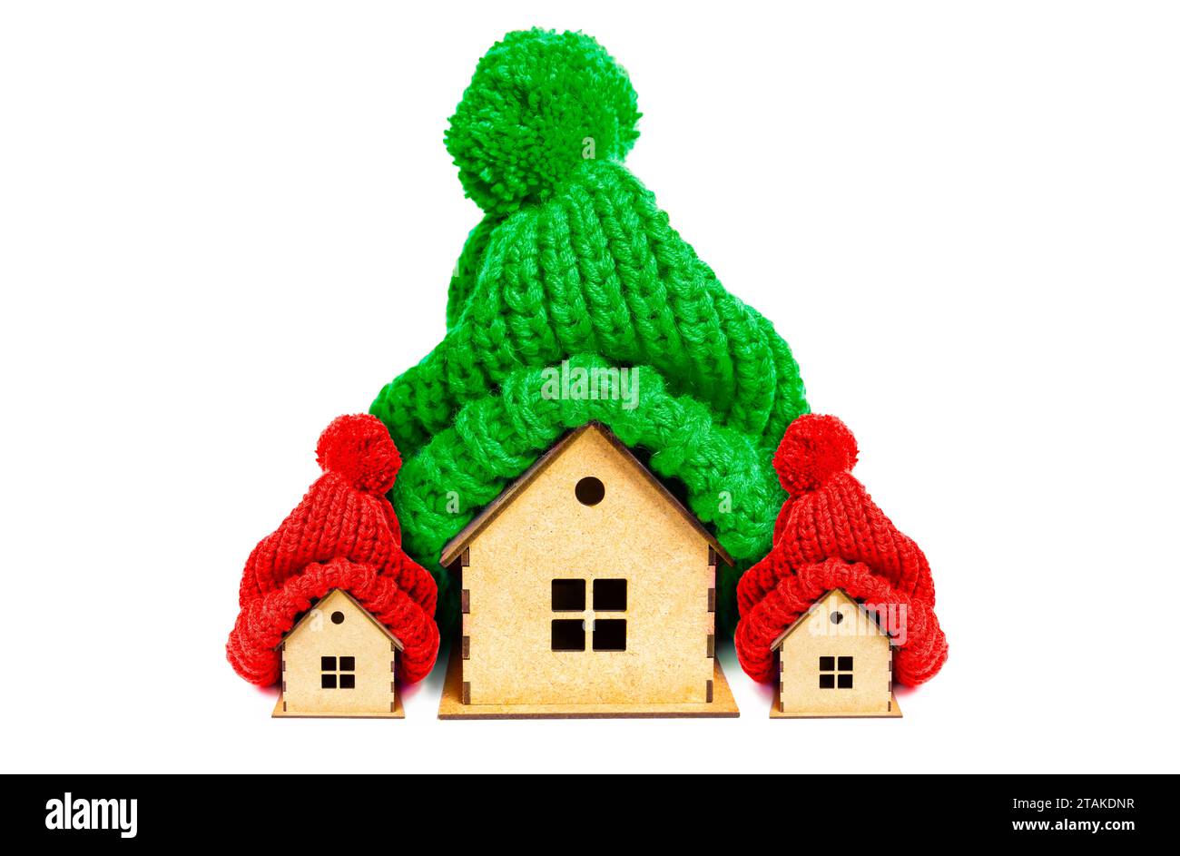 Grande maison et deux petites maisons ornées de chapeaux pompon tricotés aux couleurs festives de Noël. Réductions de Noël, promotions immobilières et vacances re Banque D'Images