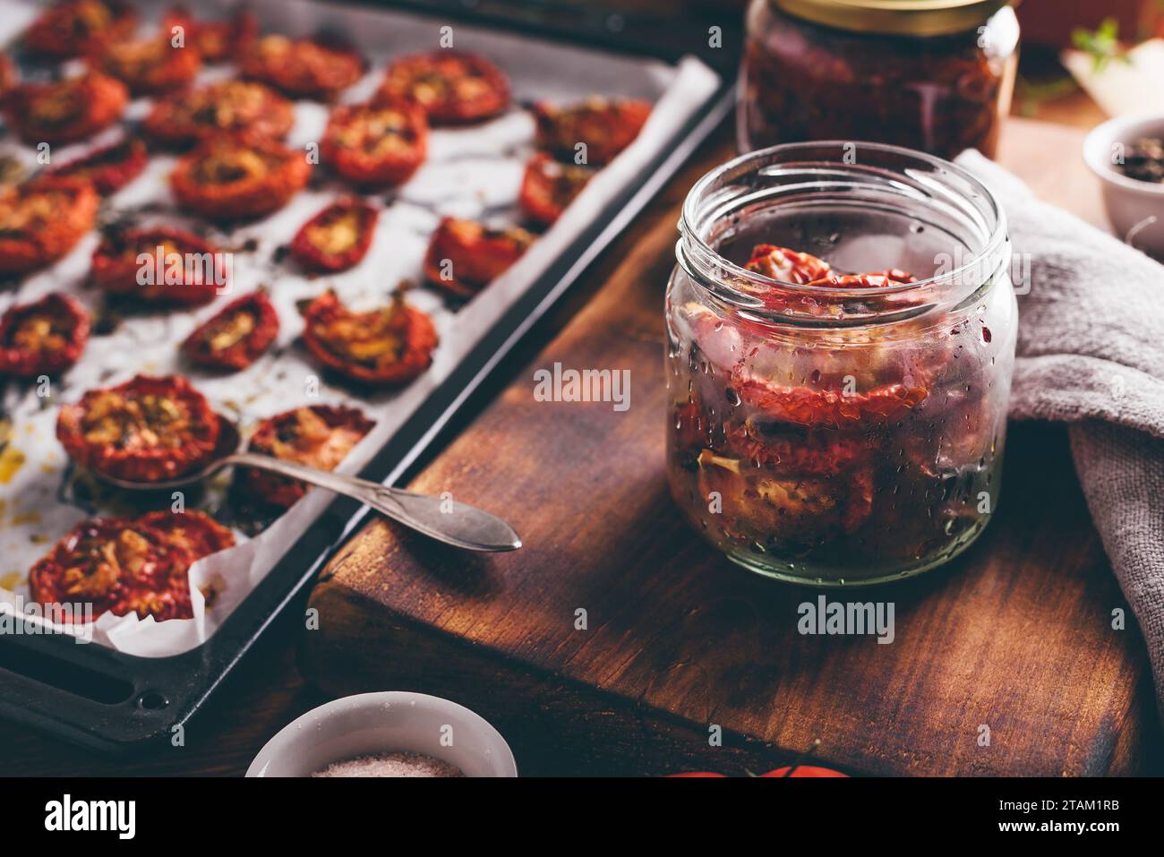 Conservation des tomates cuites au four avec de l'huile d'olive et des herbes Dans un pot en verre Banque D'Images